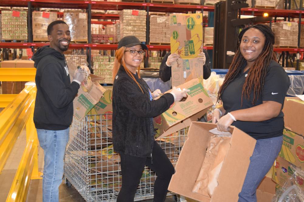Photo of students holding boxes during service project at food bank